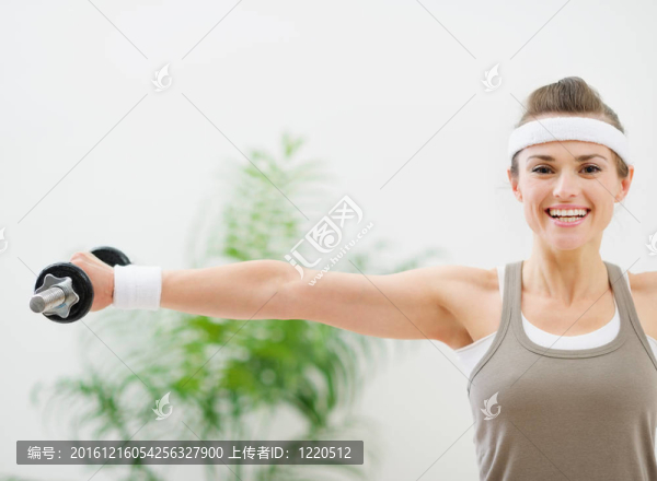 微笑的女人用啞鈴鍛煉運動