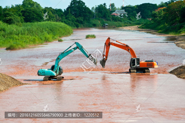 在藍(lán)色天空上提鏟斗的挖掘機(jī)裝載機(jī)