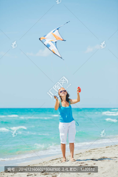 海灘上玩彩色風(fēng)箏的女人