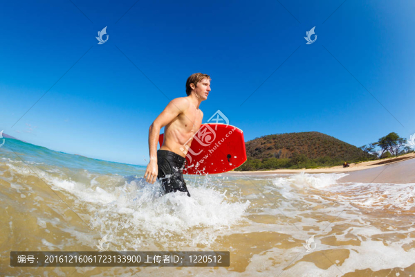 在海灘沖浪板的年輕人