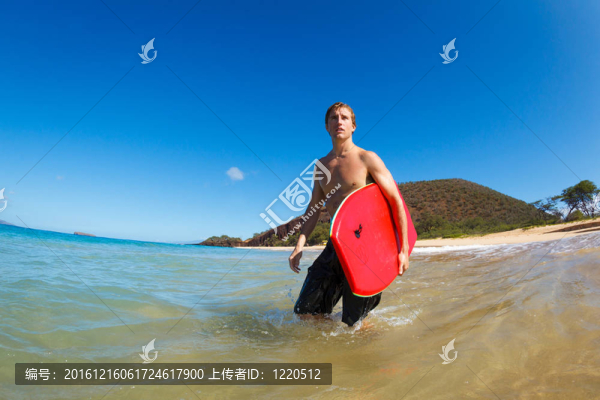在海灘沖浪板的年輕人