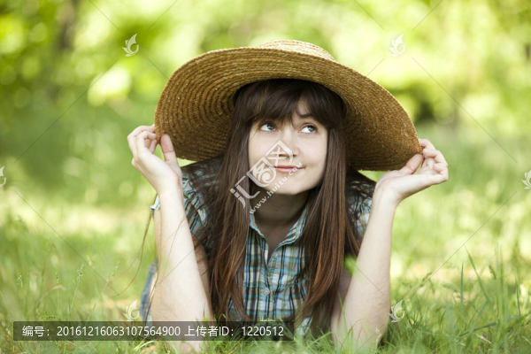 年輕的時(shí)尚女孩在白色的帽子在綠色春草。
