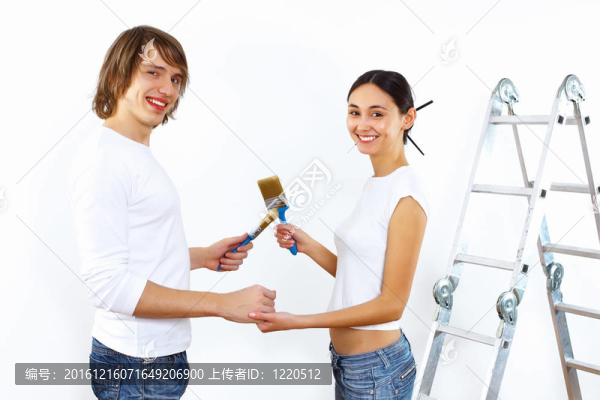 年輕夫婦一起刷油漆