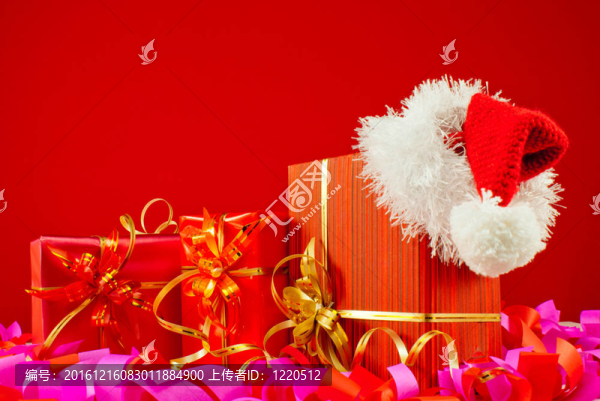 圣誕禮物與Santa的帽子反對(duì)紅色背景