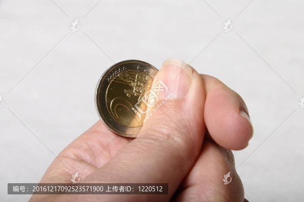 手和手指持有一二歐元硬幣清晰的背景