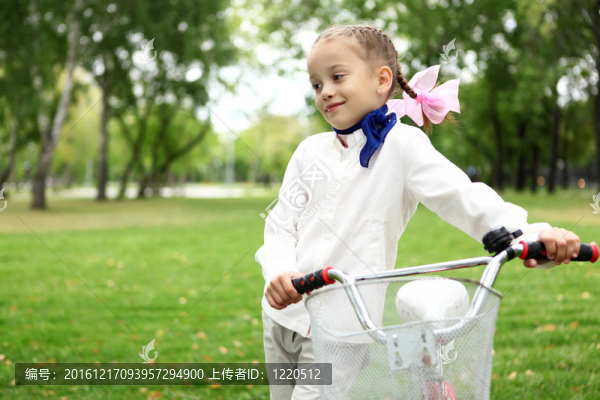 在綠色公園騎自行車的女孩