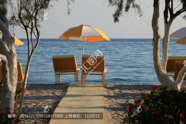 海灘上的兩把椅子和雨傘。tigaki；希臘