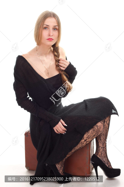 女人坐在舊皮箱上