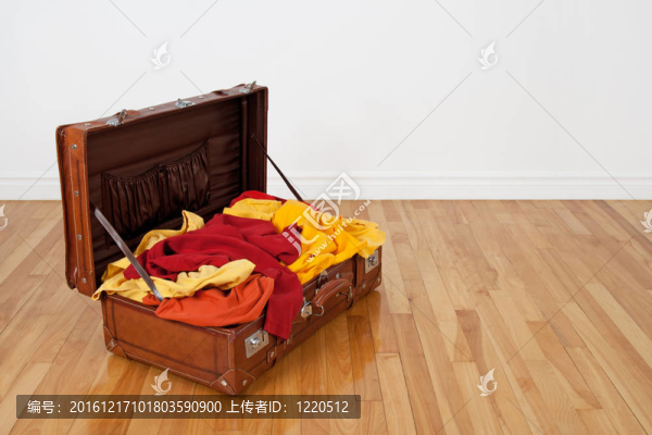裝滿橙色和黃色衣服的皮箱