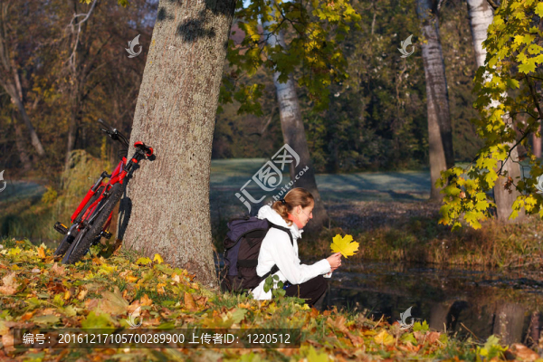 女人在秋天的公園休閑自行車