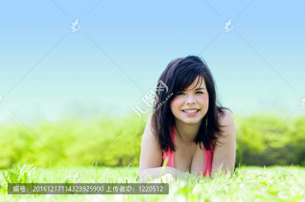年輕快樂的女孩躺在草地上