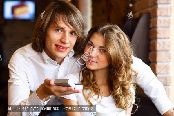 在餐廳里戴著訂婚戒指的年輕夫婦