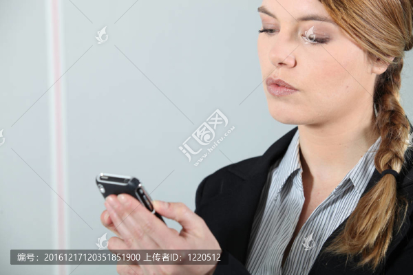 年輕的女商人檢查電話。
