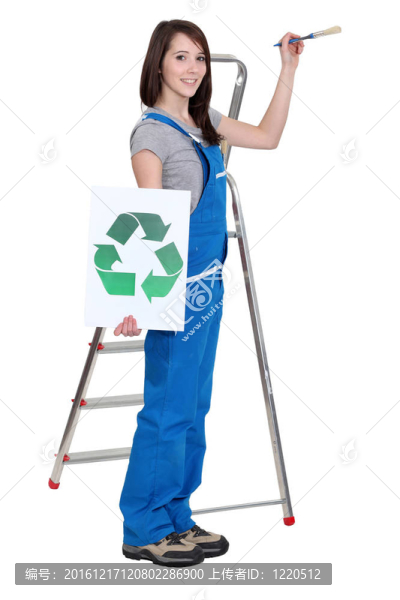 可愛的深色的畫家在藍色工作服拿著刷子和回收標志