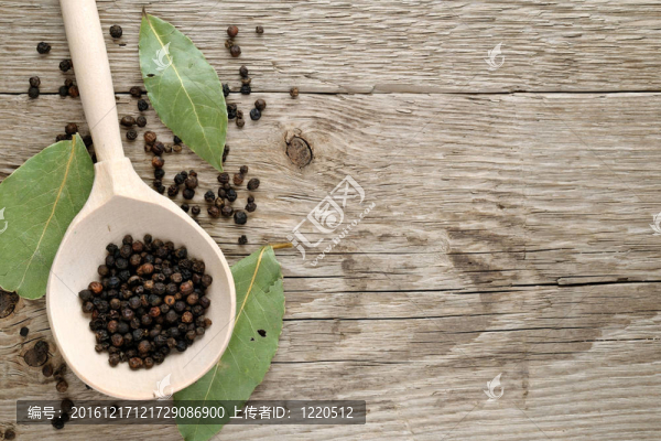 黑胡椒在湯匙和干灣葉木背景