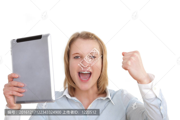 年輕的商業(yè)女性手里拿著一臺(tái)平板電腦，手里攥著拳頭歡呼