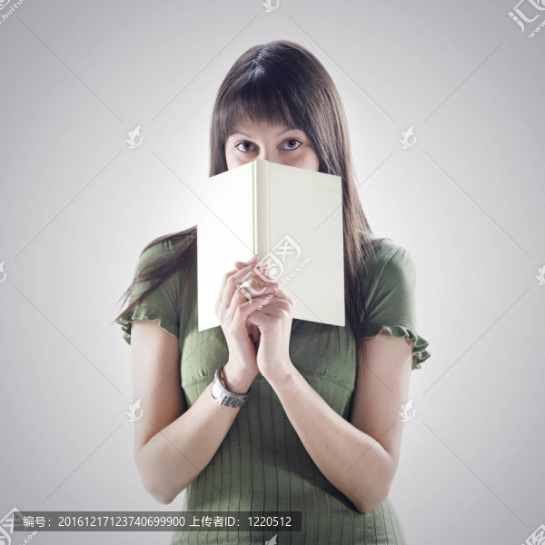 女人躲在書后面。封面是空白的