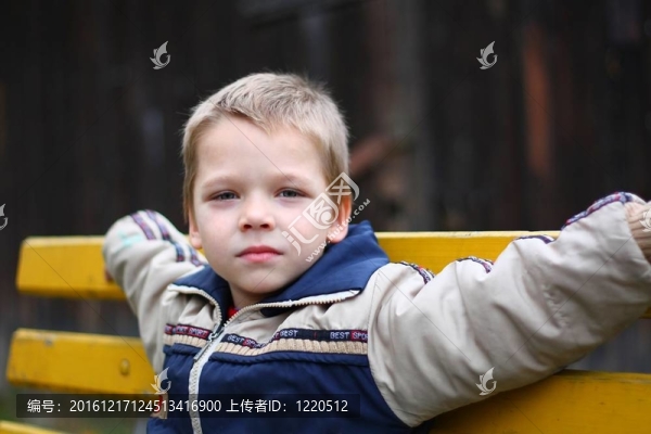坐在長凳上的小男孩