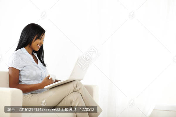 華麗的年輕婦女在筆記本電腦上工作