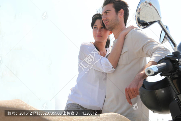 夫婦站在他們的滑板車旁邊