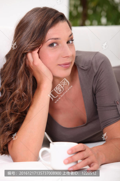 喝熱飲料的年輕婦女