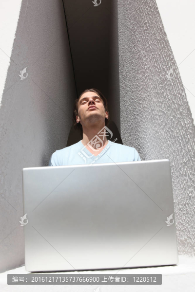 男人的凹室，曬在陽光下而使用筆記本電腦