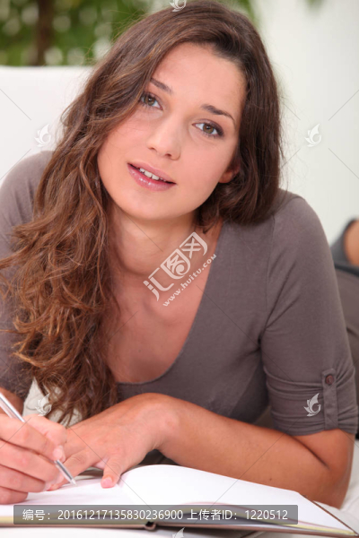 漂亮的年輕女人在書中寫作