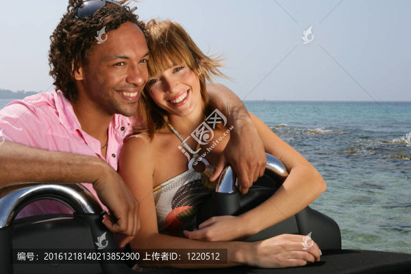 海灘上的年輕夫婦站在敞篷汽車旁邊
