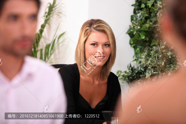 穿著黑色連衣裙的女人坐在餐館里