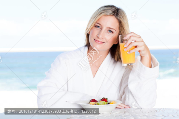 可愛(ài)的年輕女子喝橙汁