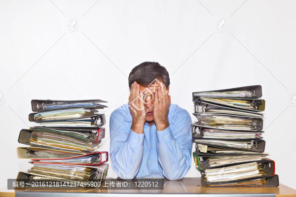 男子研究文件夾在他的辦公桌上的文件