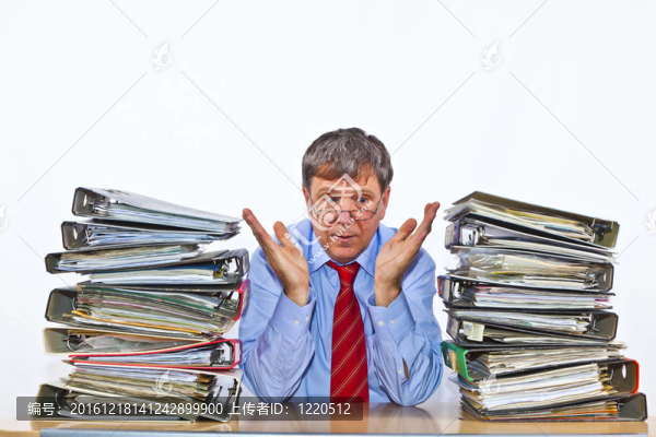 男子研究文件夾在他的辦公桌上的文件