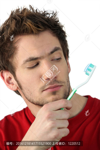 年輕人看著他的牙刷