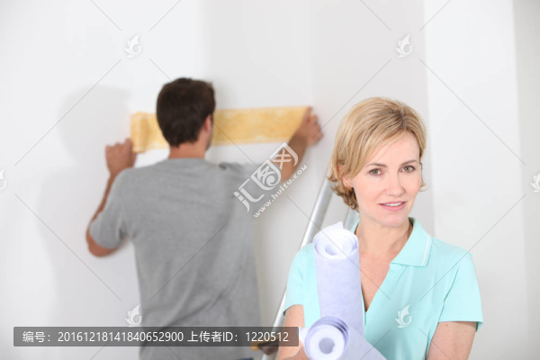 夫婦準備墻紙白色的房間
