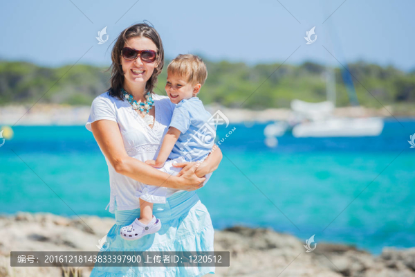 沿著熱帶海灘散步的家庭