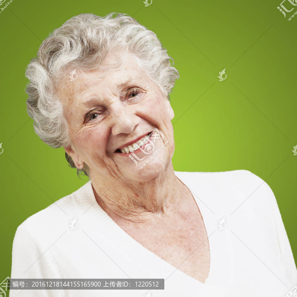 漂亮的高級女人對著綠色背景微笑