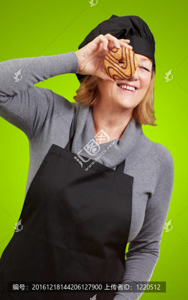 中年婦女看著廚師在綠色背景的甜甜圈