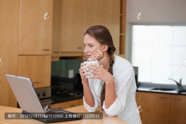 看電腦時(shí)拿著杯子的女人