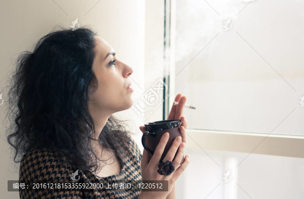 在吸煙室里喝咖啡和香煙的年輕女子