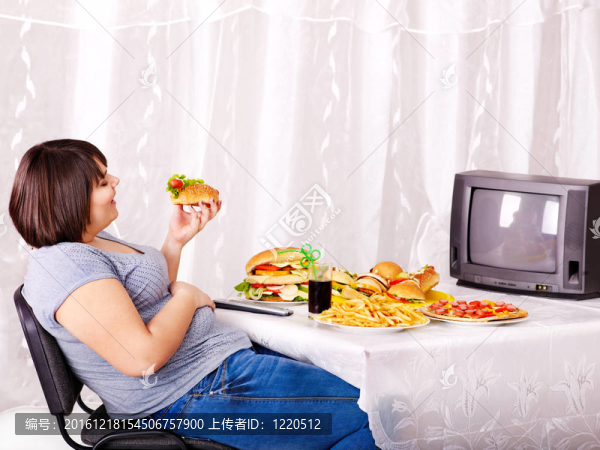 女人吃快餐和看電視。