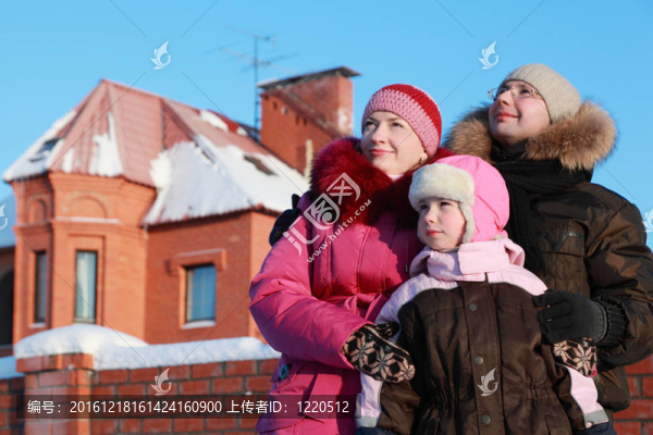 父親和母親站在戶外，在冬天附近的房子和在天空中尋找；專注于女孩