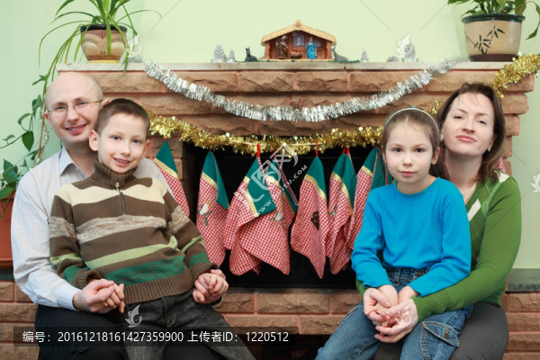 父親；母親；兒子和女兒坐在壁爐旁；圣誕飾品；幸福家庭