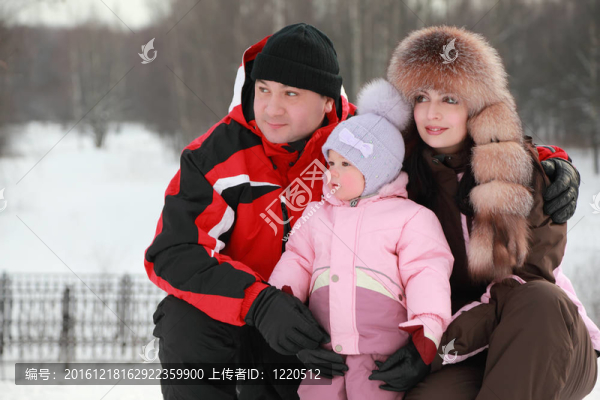 父親在雪中擁抱母親和小女兒；他們眺望遠方；冬天；關注女孩