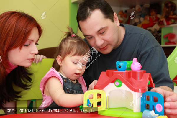 母親和父親玩他的小女兒；玩具屋；專注于女孩