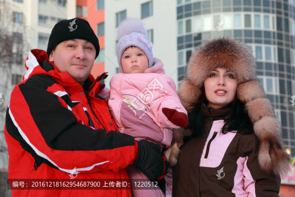 媽媽和爸爸把他的小女兒；冬季；多層建筑；關(guān)注女孩