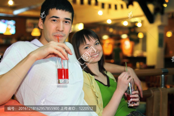 男人和女孩坐在長椅上喝雞尾酒，關注男人