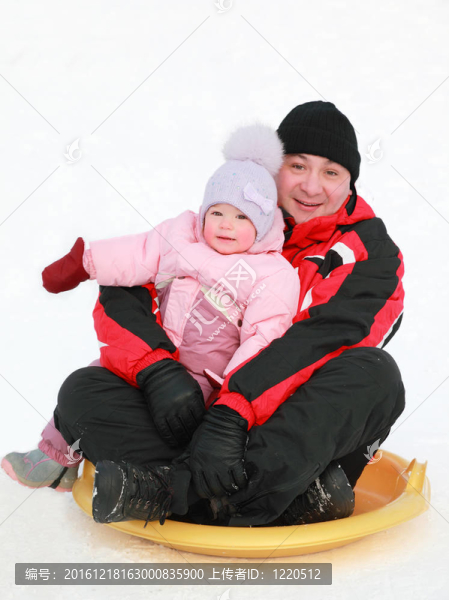 父親帶著他的小女兒冬天在雪上滾雪，關(guān)注女孩