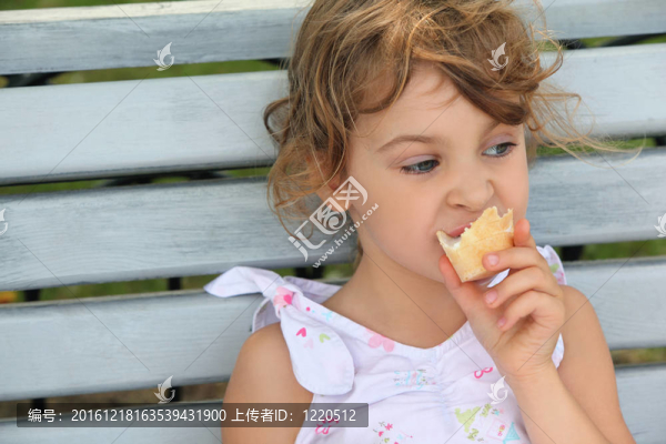 小女孩坐在長凳上吃冰淇淋
