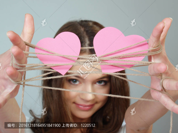 美麗的女孩手中握著兩顆粉紅色的心