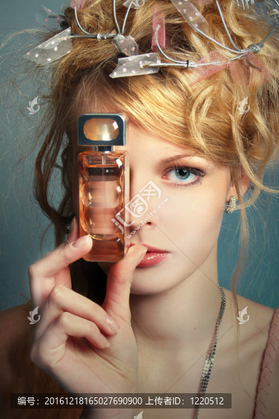 漂亮女孩的臉上帶著一瓶香水